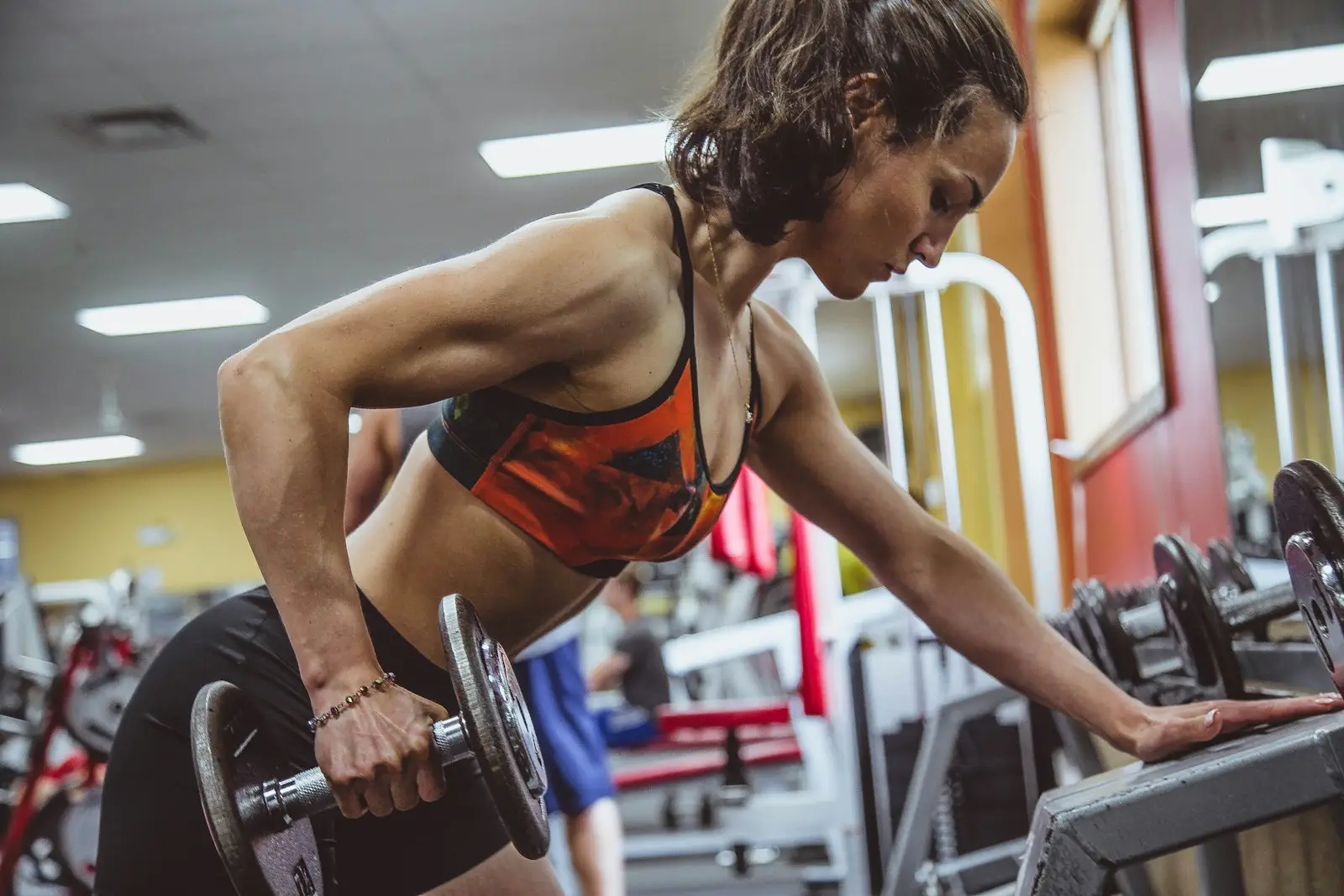 Woman doing a dumbbell row in the gym