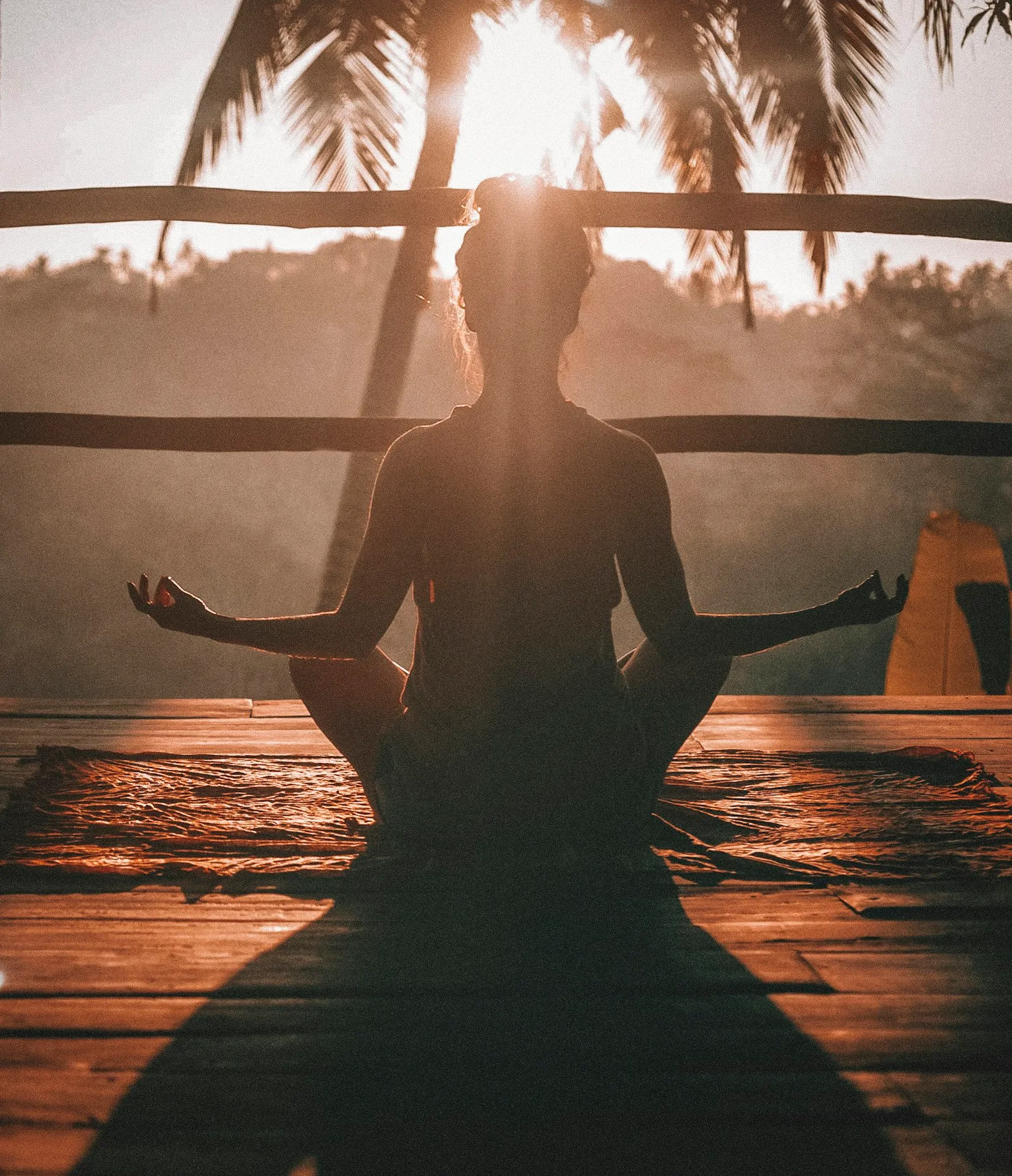 Person meditating at sunrise