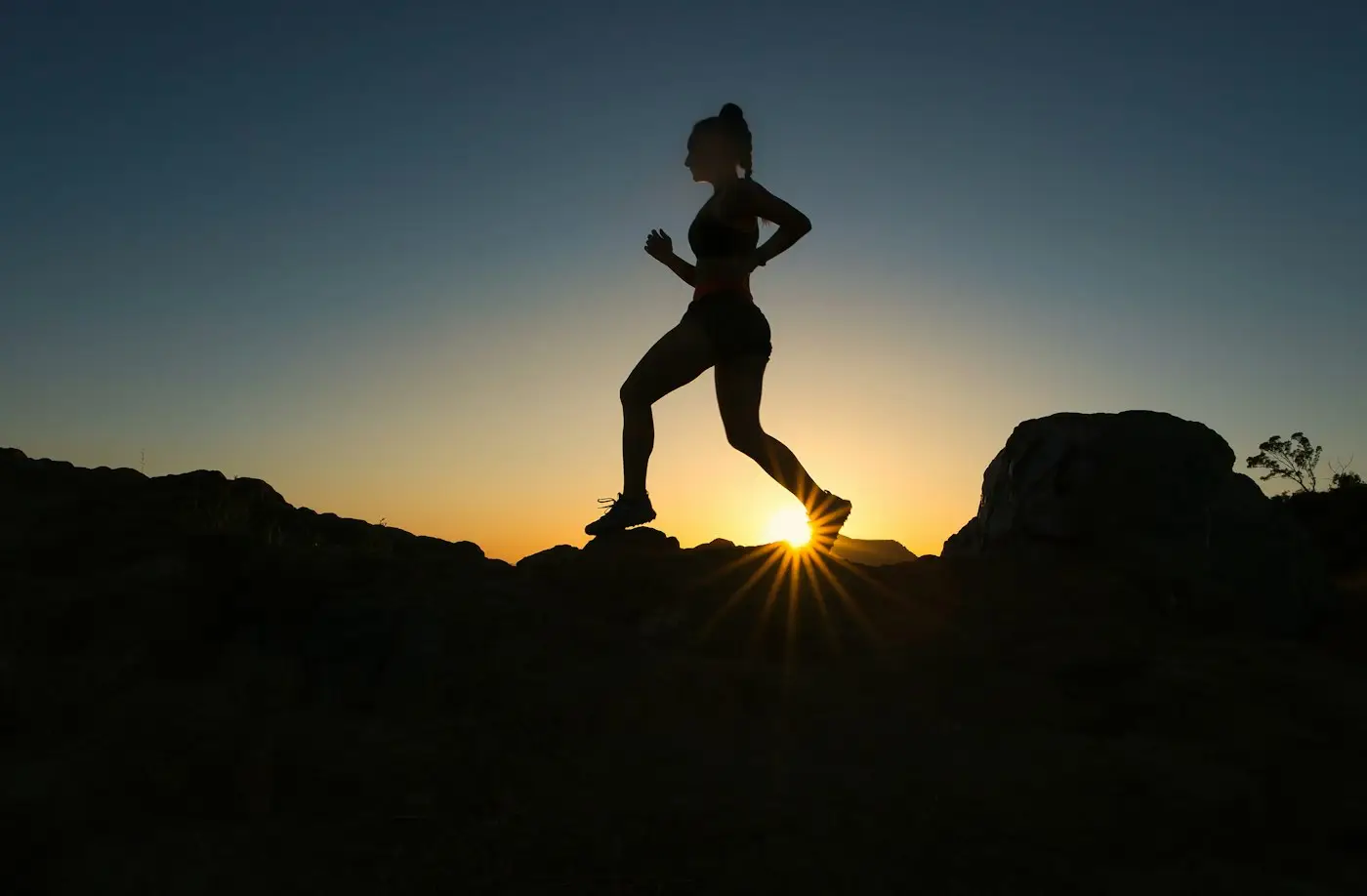 Runner silhouetted at sunrise